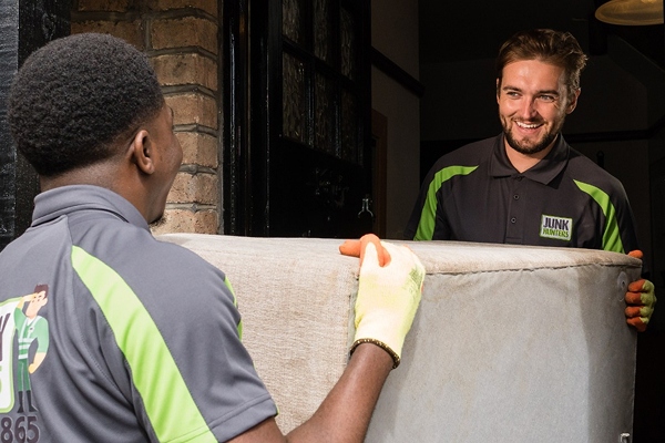 Two person professional team safely removing a large sofa.