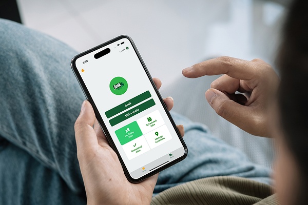 A person is easily booking a waste collection time via JunkApp, while relaxing.